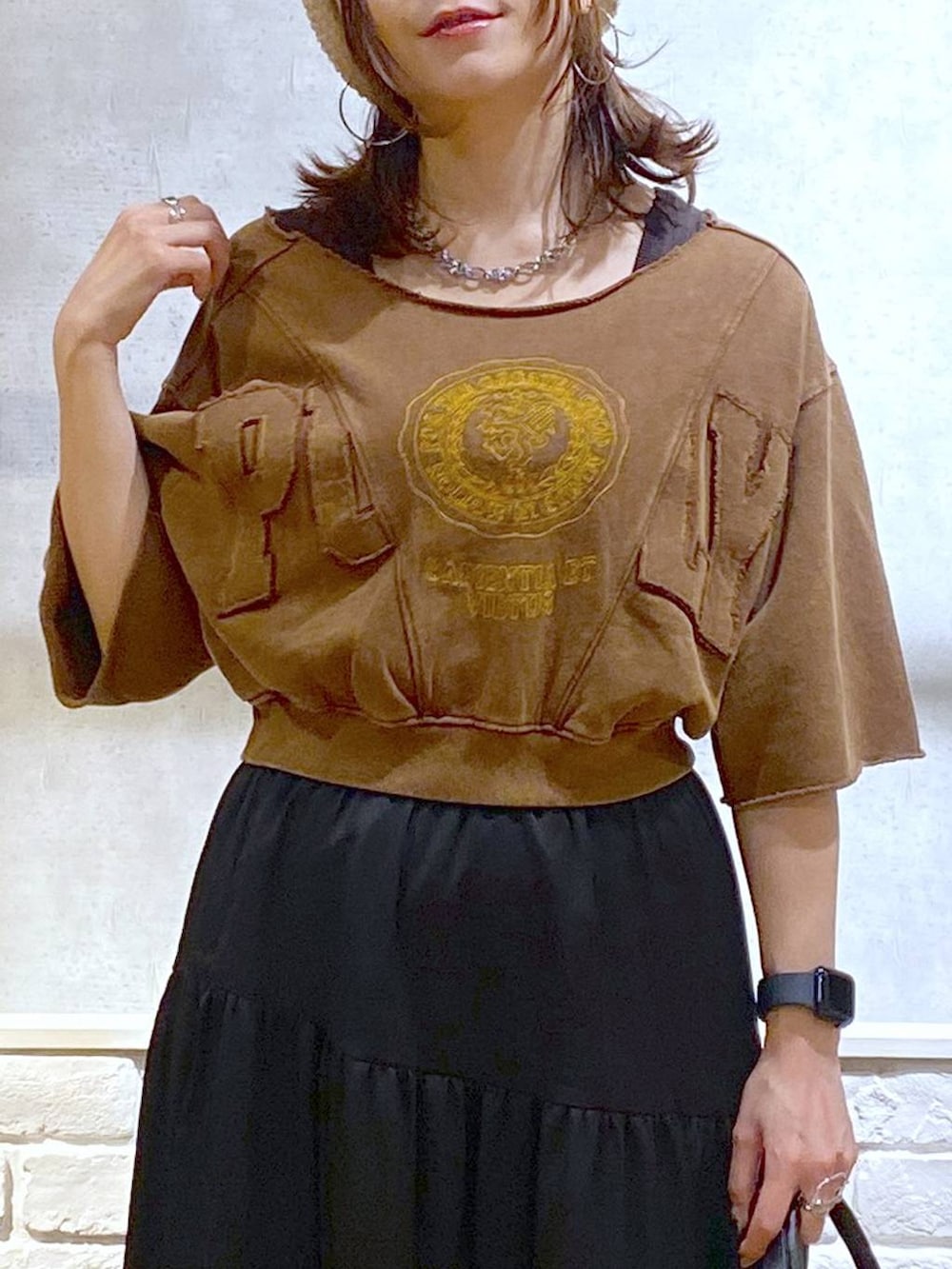 ブラウン系のタンクトップ、ブラック系のショルダーバッグ、ホワイト系のスニーカーを着用したレディースの夏コーディネートの2枚目の写真