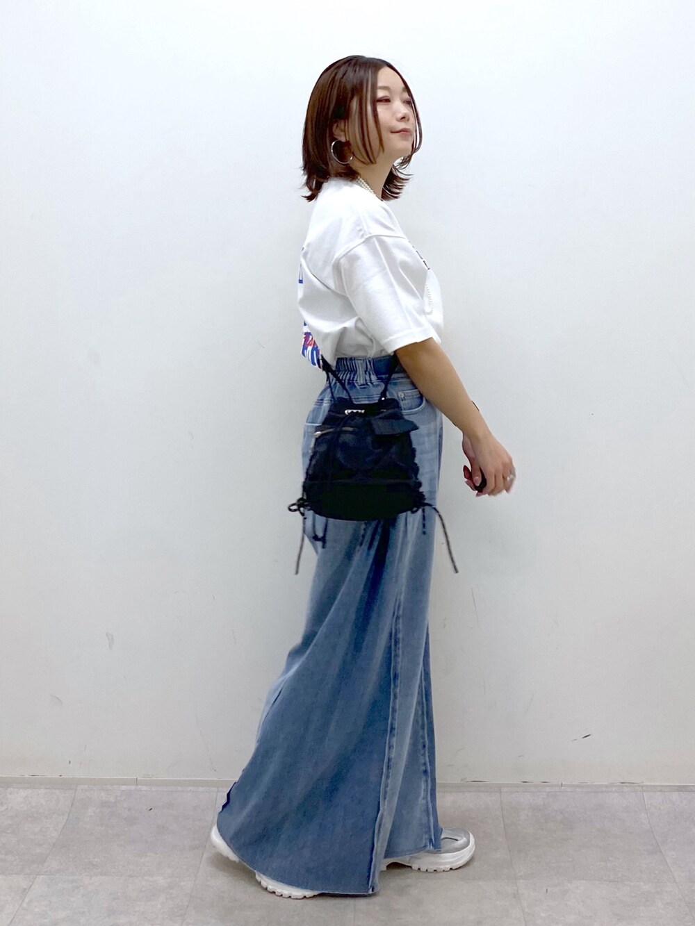 ホワイト系のTシャツ/カットソー、ブラック系のボディバッグ/ウエストポーチ、ブルー系のデニムパンツを着用したレディースの春コーディネートの6枚目の写真