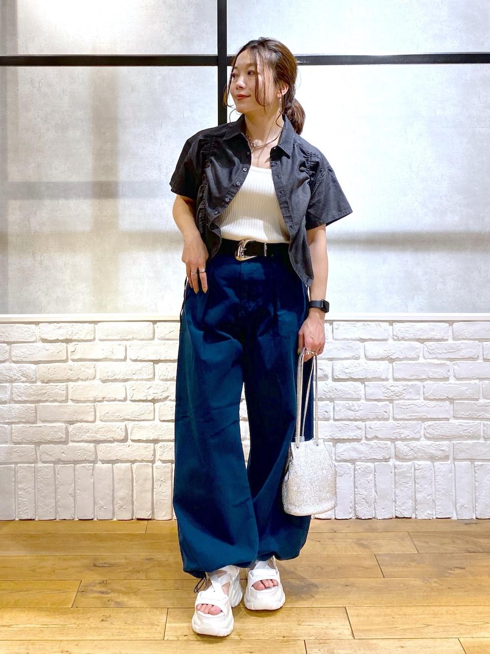 ホワイト系のタンクトップ、ブルー系のチノパンツ、ホワイト系のサンダルを着用したレディースの春コーディネートの8枚目の写真