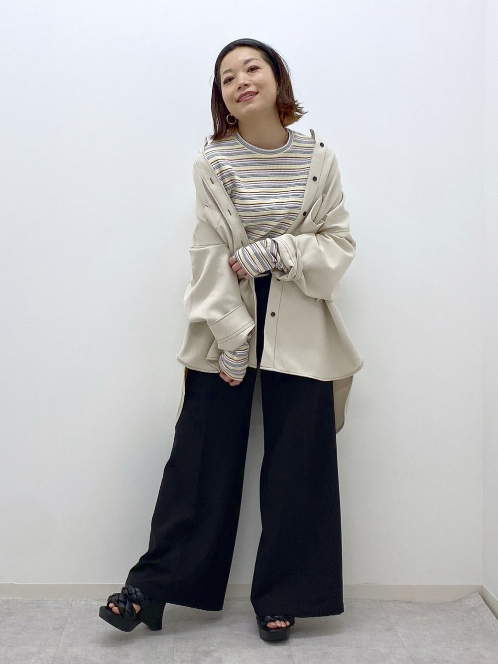 ホワイト系のシャツ/ブラウス、ホワイト系のTシャツ/カットソー、ブラック系のスラックスを着用したレディースの春コーディネートの2枚目の写真