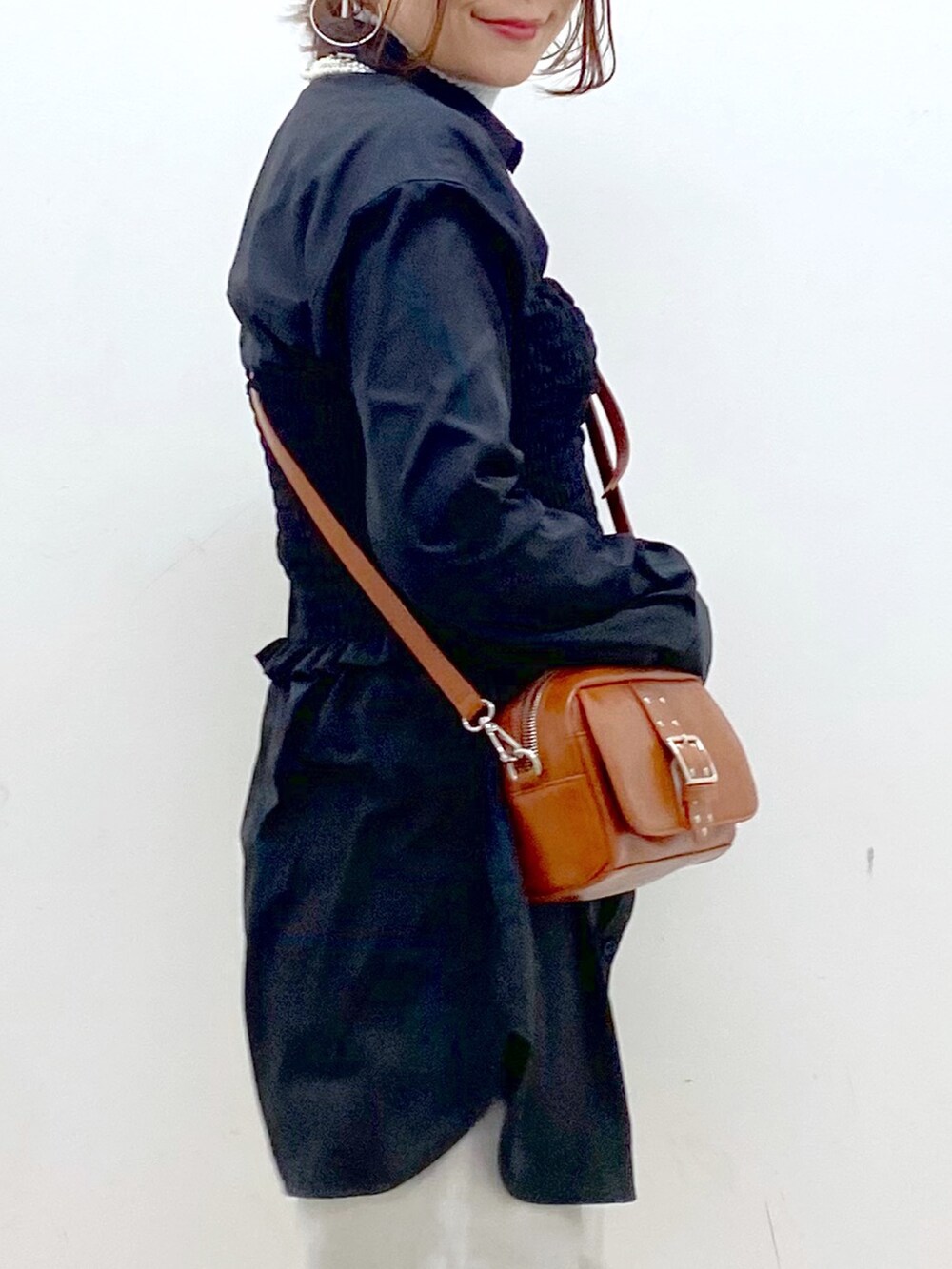 ブラック系のシャツ/ブラウス、ベージュ系のショルダーバッグ、グレー系のデニムパンツを着用したレディースの冬コーディネートの2枚目の写真