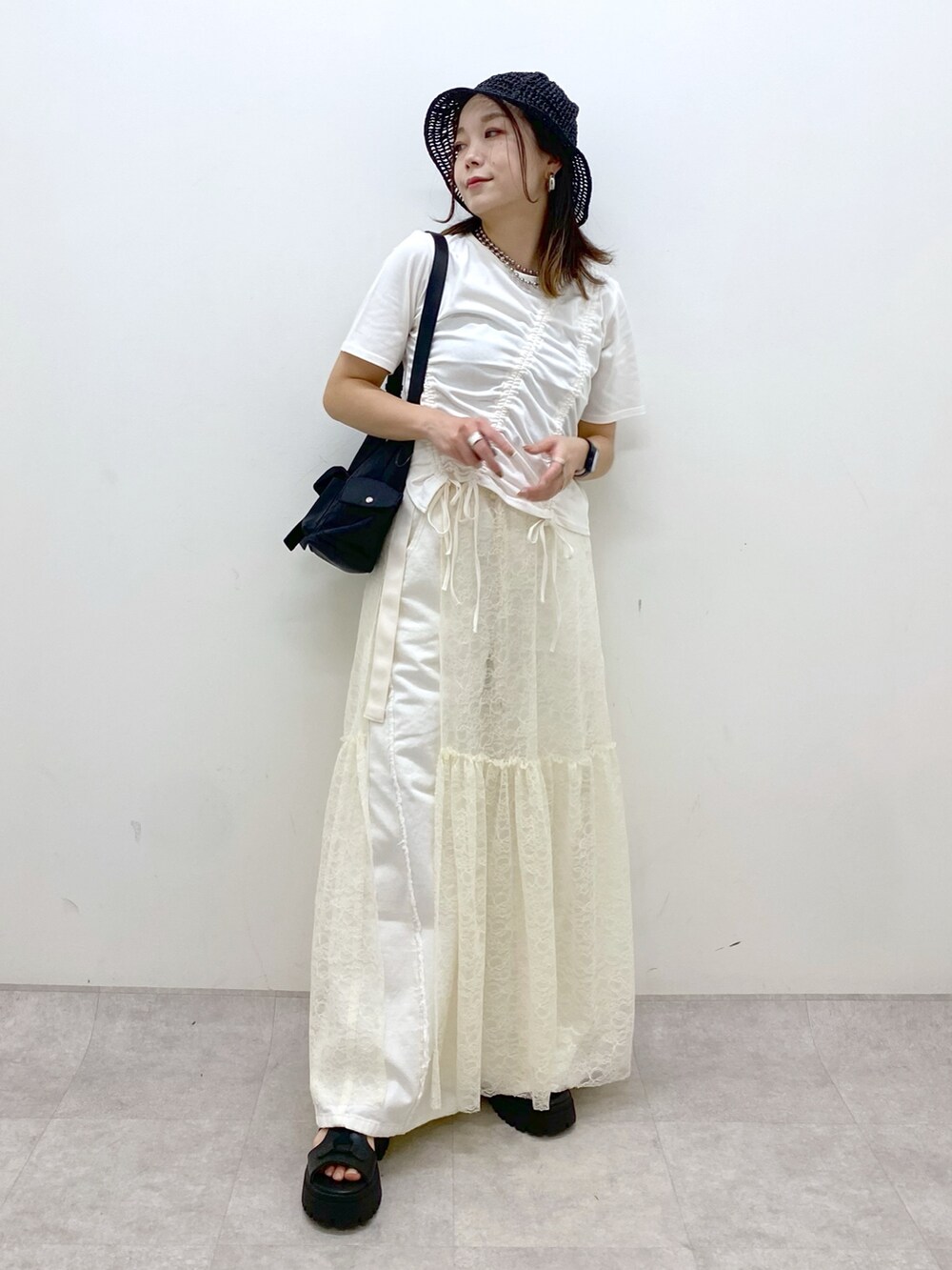 ホワイト系のTシャツ/カットソー、ブラック系のサンダル、ホワイト系のデニムパンツを着用したレディースの春コーディネートの4枚目の写真