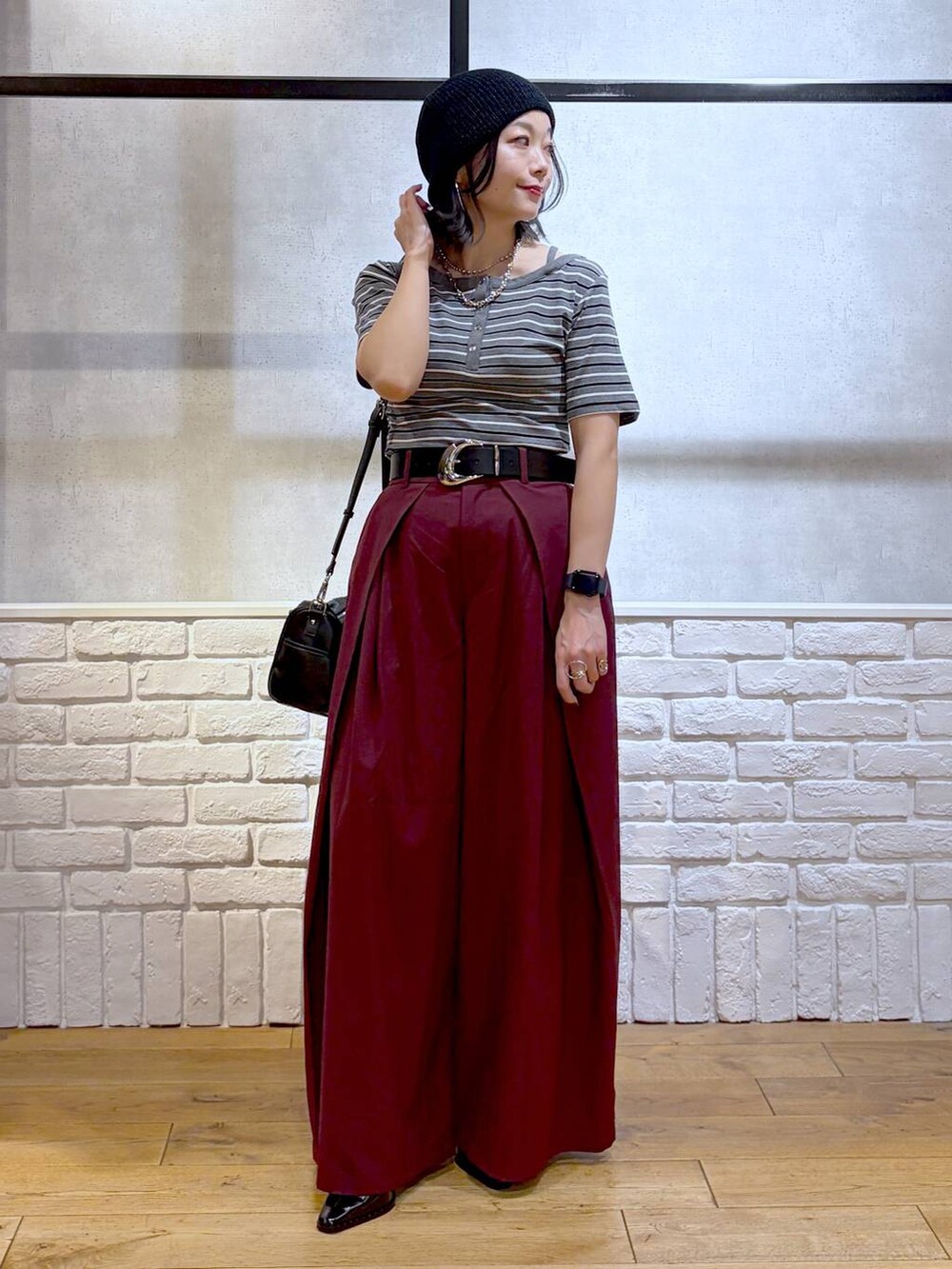 ブラック系のショルダーバッグ、レッド系のスラックス、グレー系のTシャツ/カットソーを着用したレディースの夏コーディネートの9枚目の写真