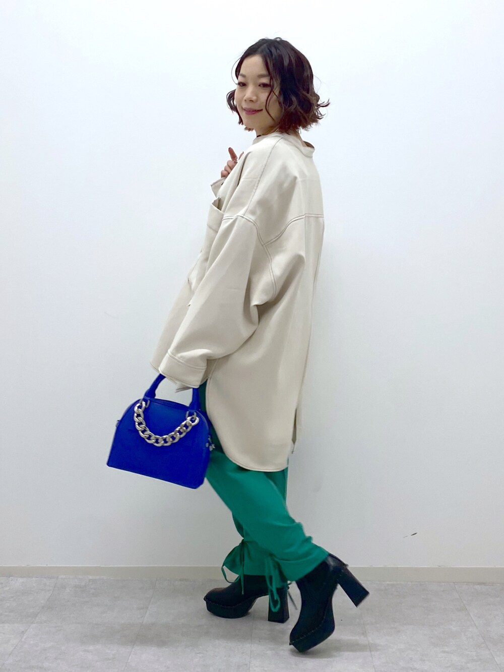 ブラック系のブーツ、ホワイト系のシャツ/ブラウス、グリーン系のその他パンツを着用したレディースの冬コーディネートの3枚目の写真