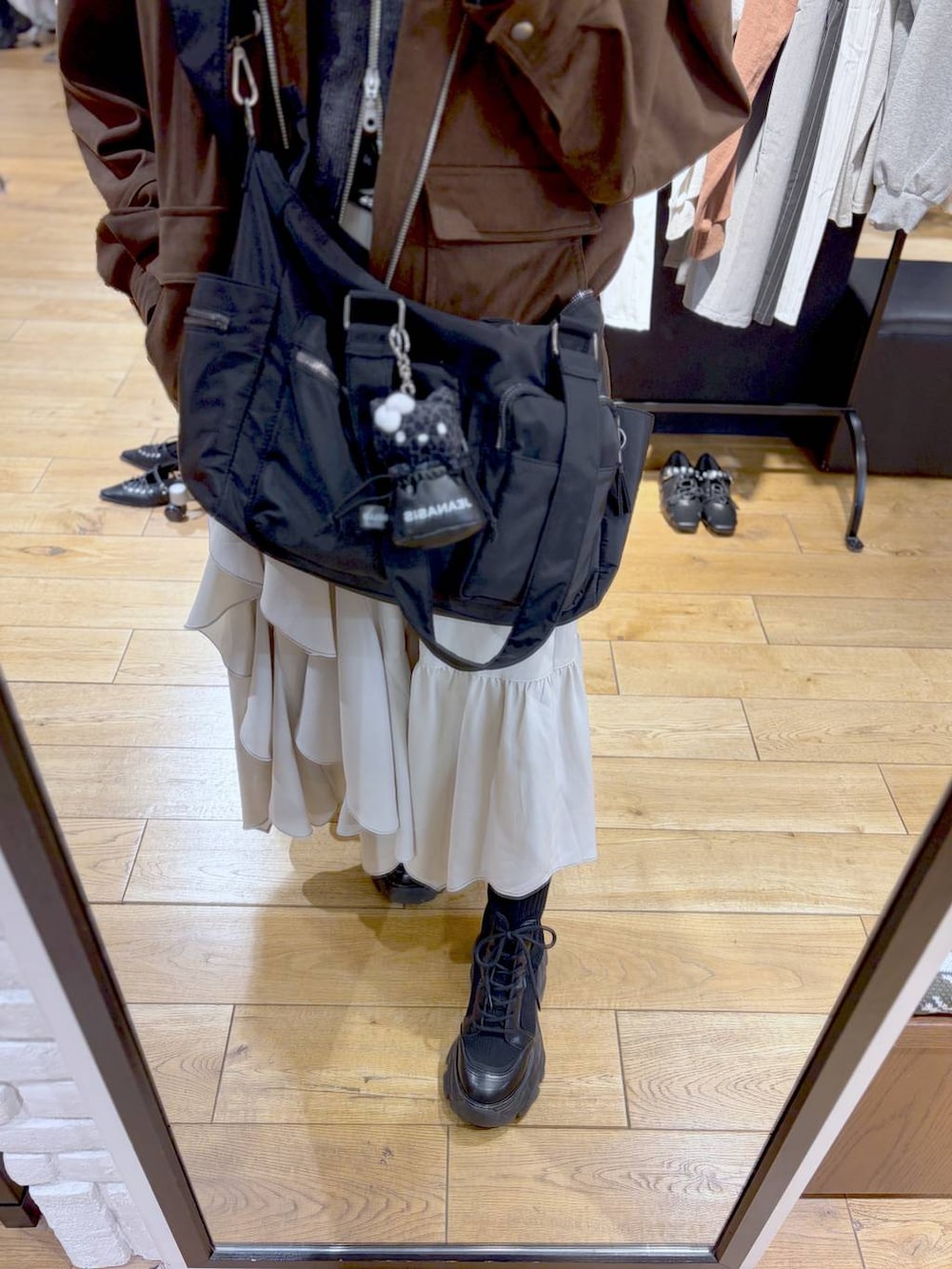 ブラック系のブーツ、ブラック系のボストンバッグ、ブラウン系のブルゾンを着用したレディースの冬コーディネートの3枚目の写真