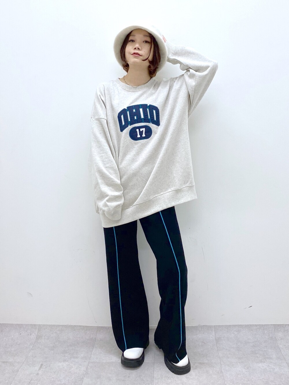 ベージュ系のトップス、ブラック系のパンツ、ホワイト系のシューズを着用したレディースの秋コーディネートの2枚目の写真