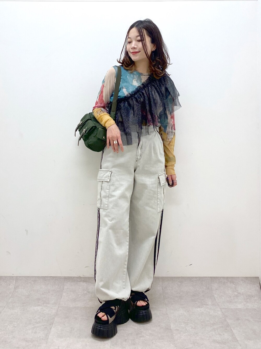グリーン系のショルダーバッグ、その他のスニーカー、ホワイト系のデニムパンツを着用したレディースの春コーディネートの8枚目の写真