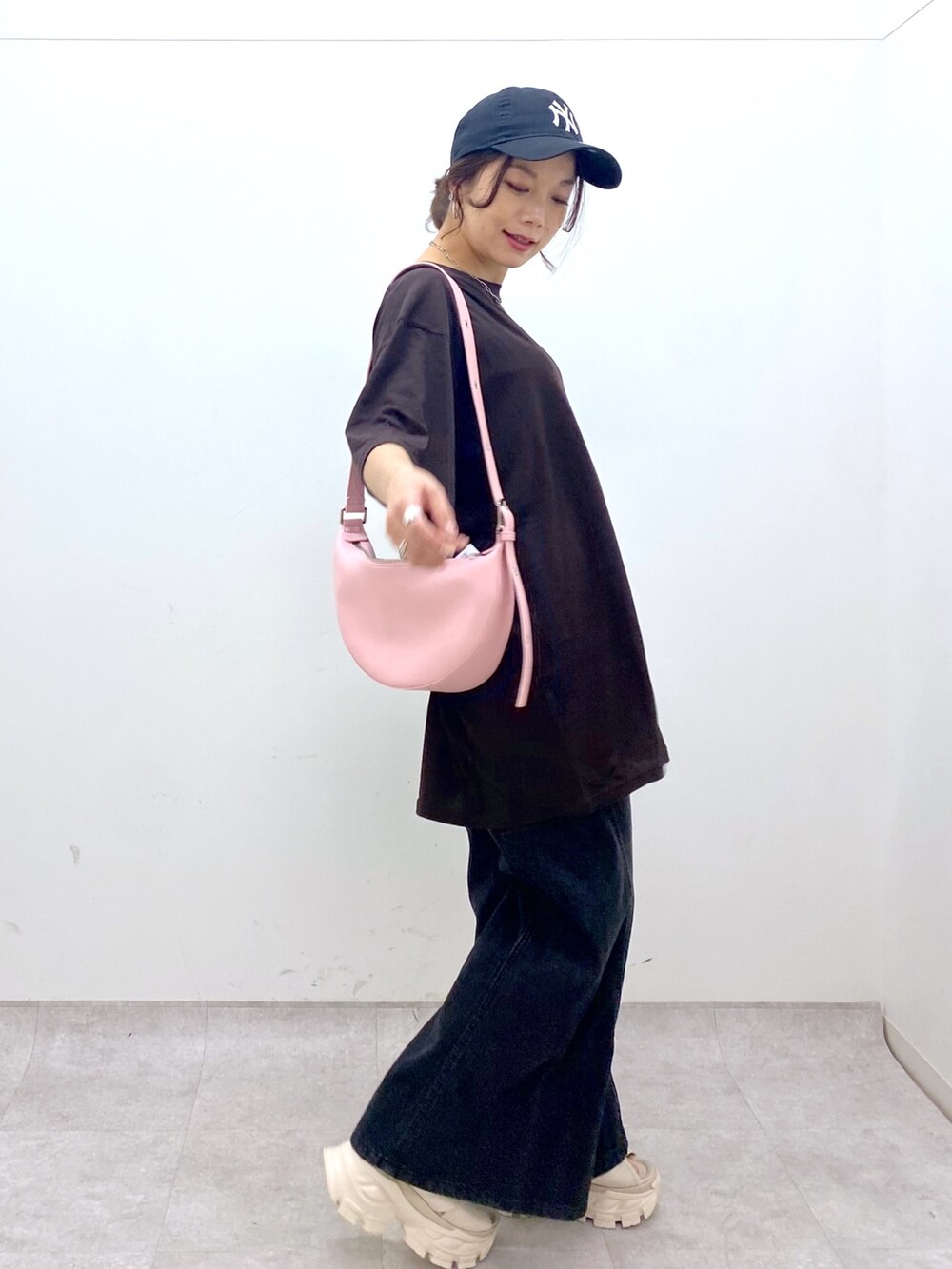 ピンク系のショルダーバッグ、ブラウン系のTシャツ/カットソー、ブラック系のデニムパンツを着用したレディースの夏コーディネートの3枚目の写真