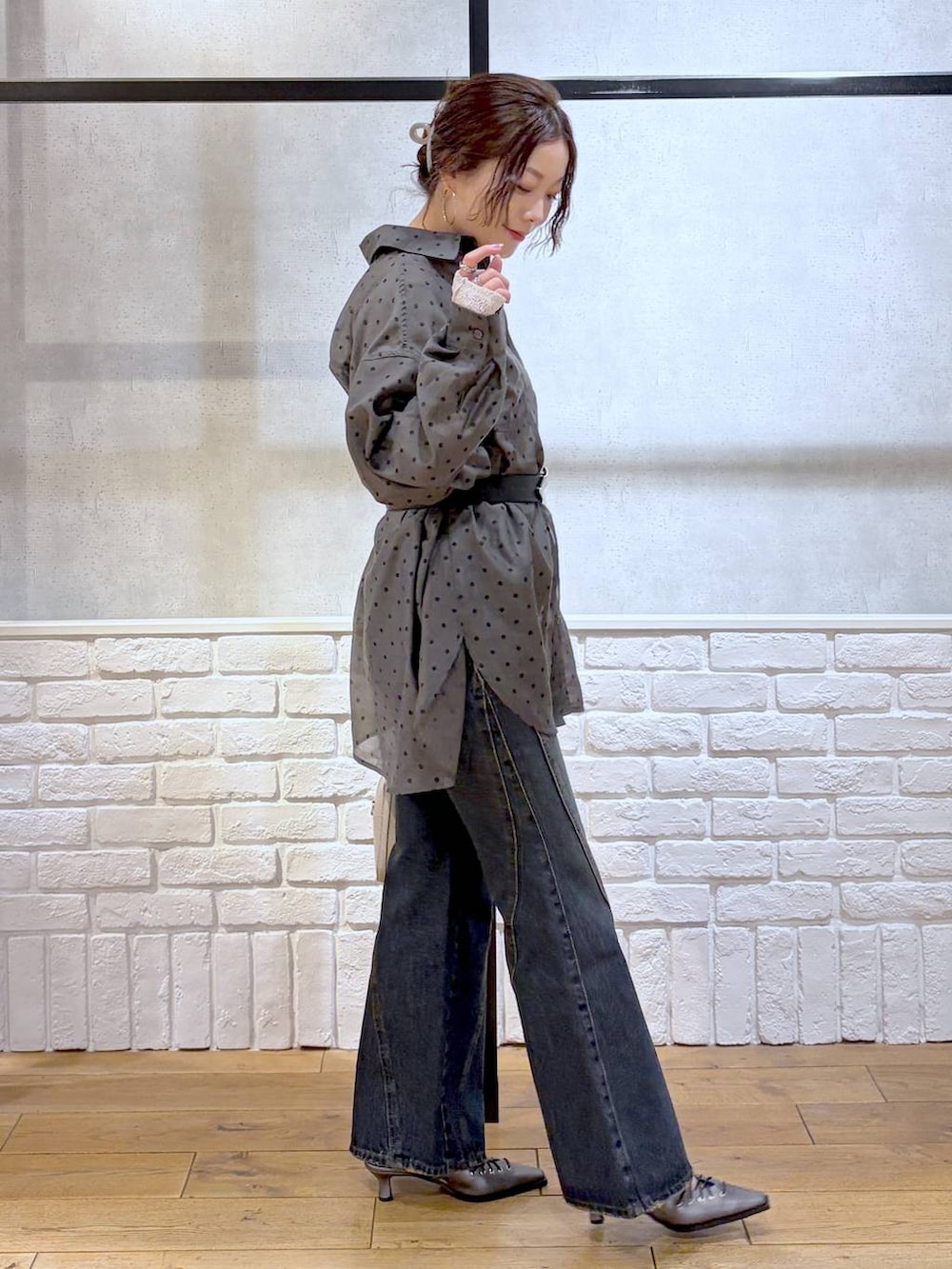 ブルー系のデニムパンツ、ホワイト系のボストンバッグ、ブラウン系のサンダルを着用したレディースの春コーディネートの3枚目の写真