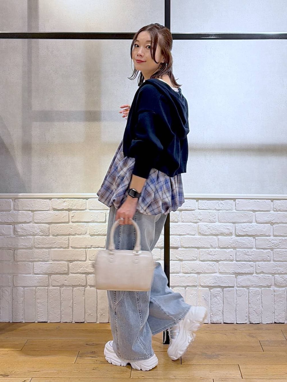 ホワイト系のスニーカー、ホワイト系のボストンバッグ、ブルー系のパーカーを着用したレディースの春コーディネートの7枚目の写真