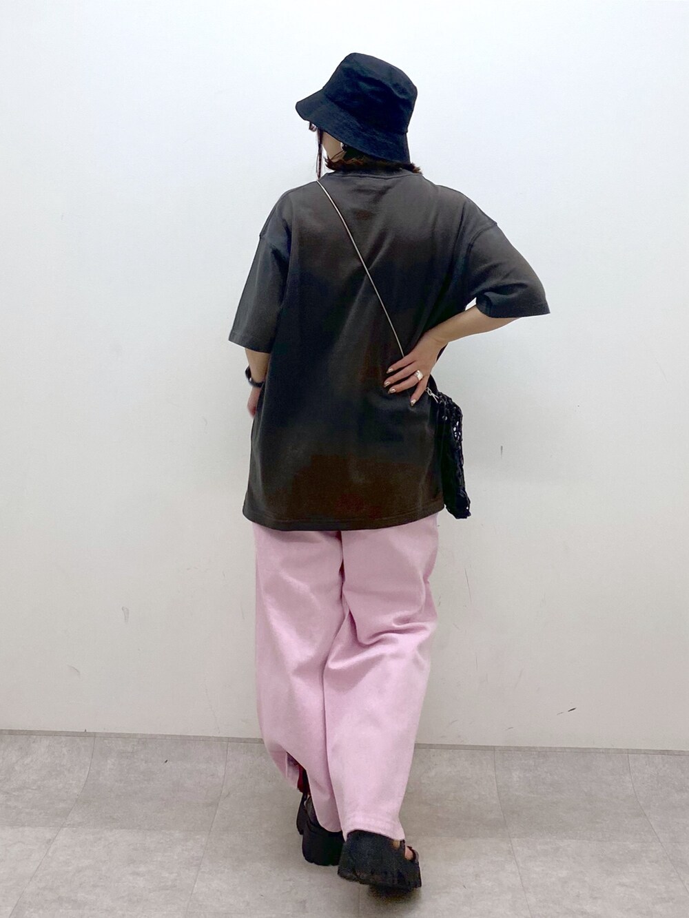 ピンク系のデニムパンツ、ブラック系のサンダル、ブラック系のショルダーバッグを着用したレディースの夏コーディネートの6枚目の写真