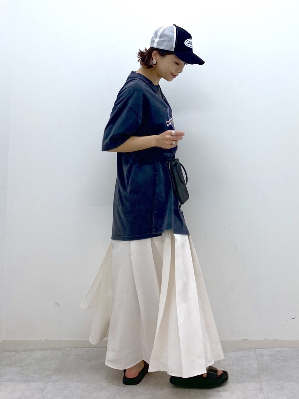 グレー系のTシャツ/カットソー、ホワイト系のスカート、ブラック系のサンダルを着用したレディースの夏コーディネートの2枚目の写真