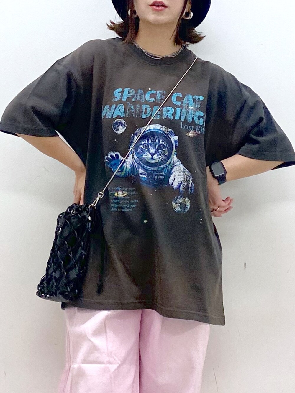 ピンク系のデニムパンツ、ブラック系のサンダル、ブラック系のショルダーバッグを着用したレディースの夏コーディネートの2枚目の写真