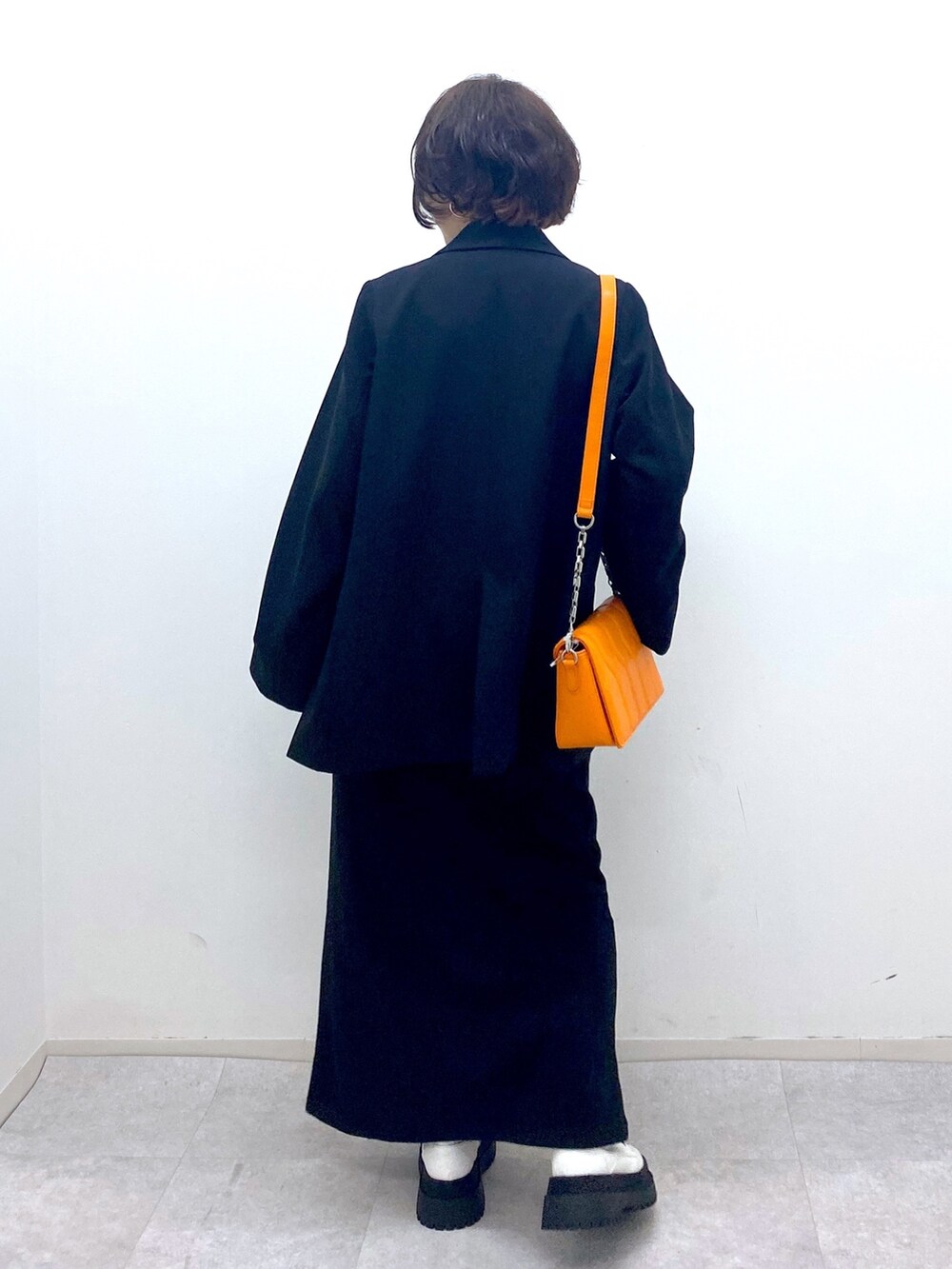 ブラック系のスカート、ホワイト系のブーツ、ブラック系のジャケット/アウターを着用したレディースの秋コーディネートの4枚目の写真