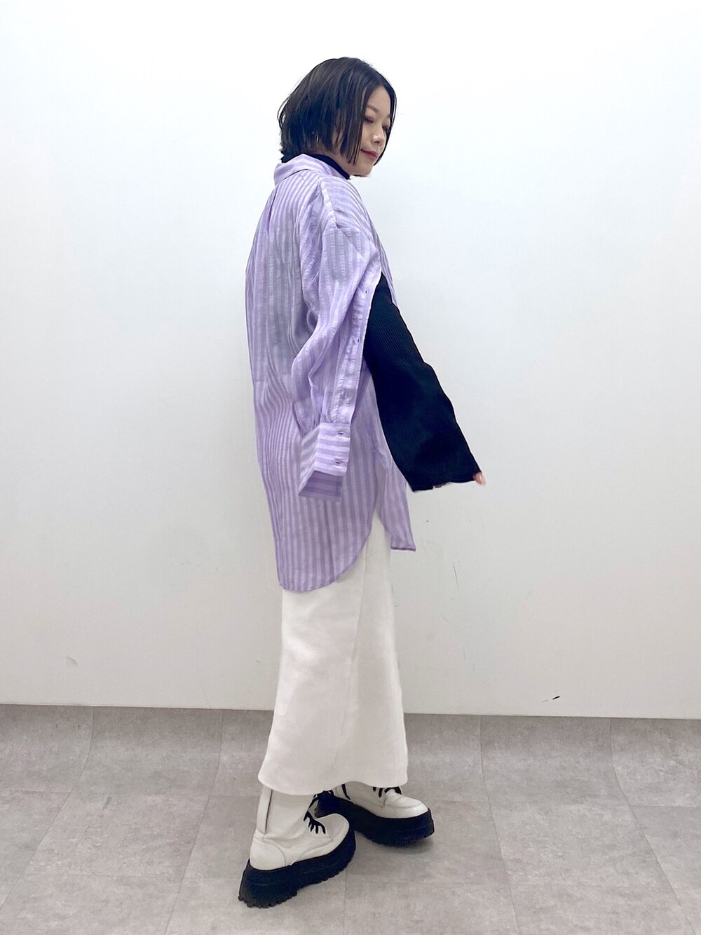 パープル系のトップス、ホワイト系のスカート、ホワイト系のシューズを着用したレディースの春コーディネートの3枚目の写真