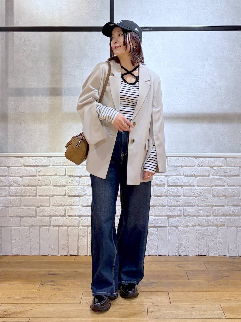 ブラック系のローファー、ブルー系のスラックス、ブラウン系のボストンバッグを着用したレディースの冬コーディネートの6枚目の写真