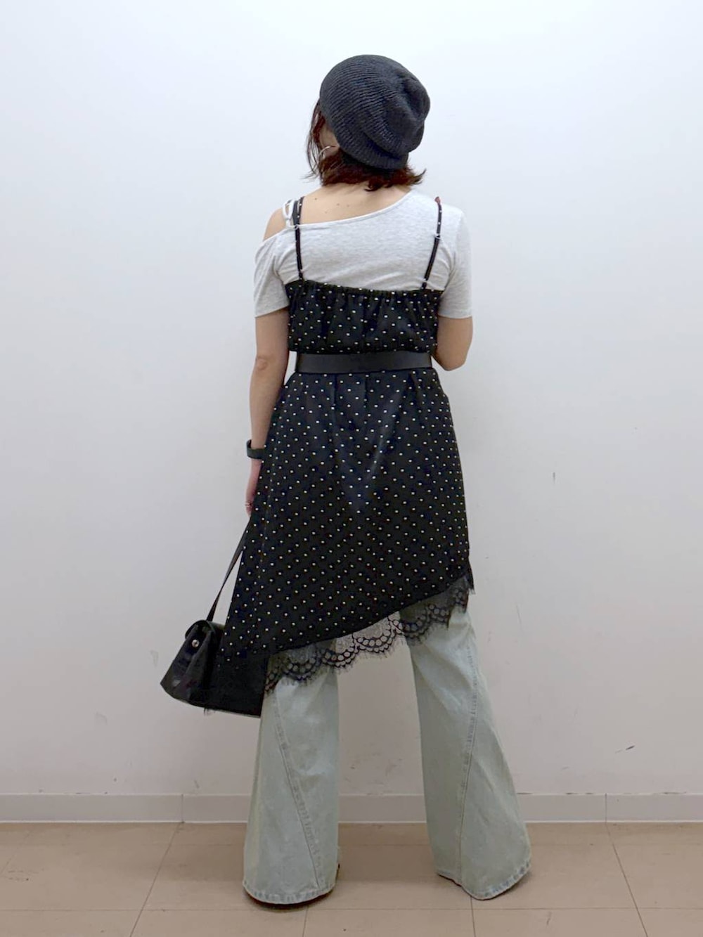 ブラック系のチュニック、ブルー系のデニムパンツ、その他のサンダルを着用したレディースの夏コーディネートの6枚目の写真