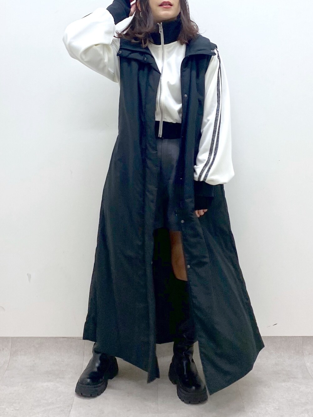 ブラック系のベスト、ブラック系のブーツ、ホワイト系のジャージを着用したレディースの秋コーディネートの8枚目の写真