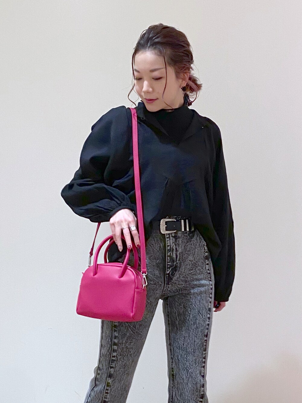 ブラック系のデニムパンツ、ホワイト系のサンダル、ピンク系のボストンバッグを着用したレディースの冬コーディネートの5枚目の写真