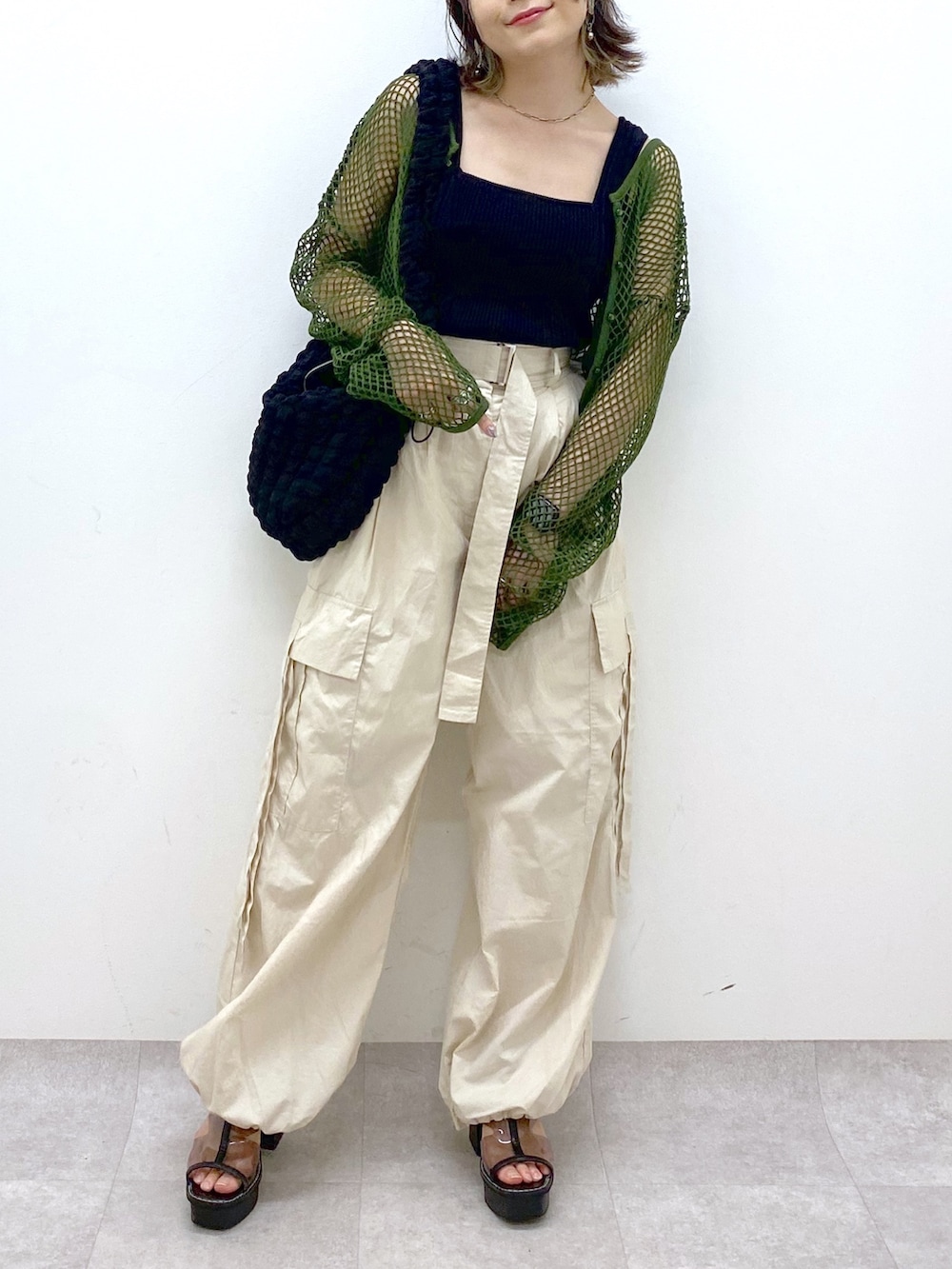 ホワイト系のカーゴパンツ、ブラック系のトップス、グリーン系のTシャツ/カットソーを着用したレディースの夏コーディネートの6枚目の写真