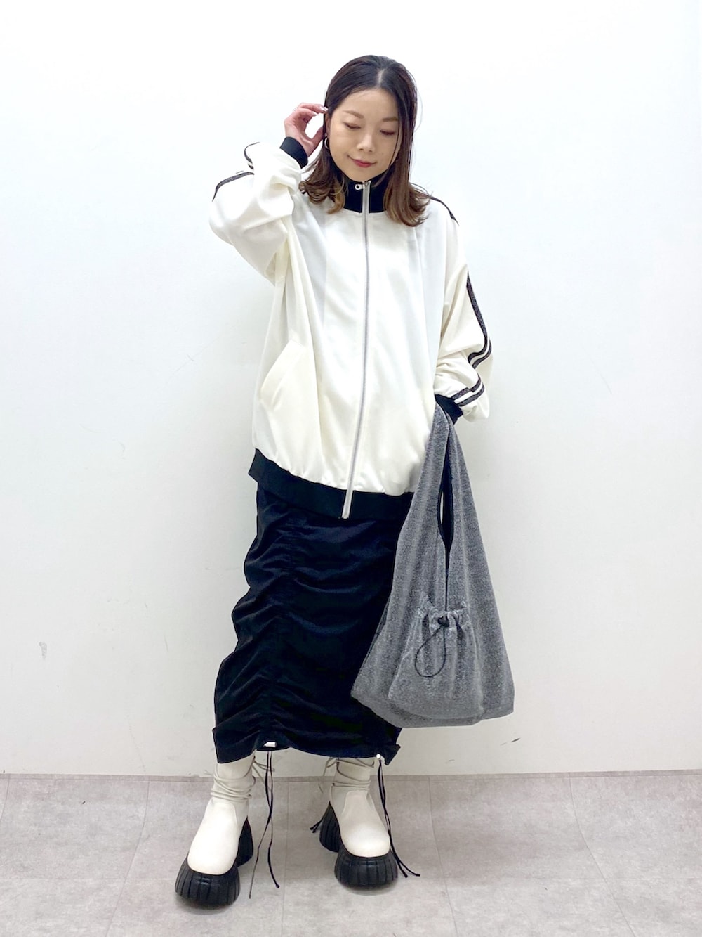 ブラック系のワンピース、ホワイト系のその他アウター、ブラック系のトートバッグを着用したレディースの冬コーディネートの9枚目の写真