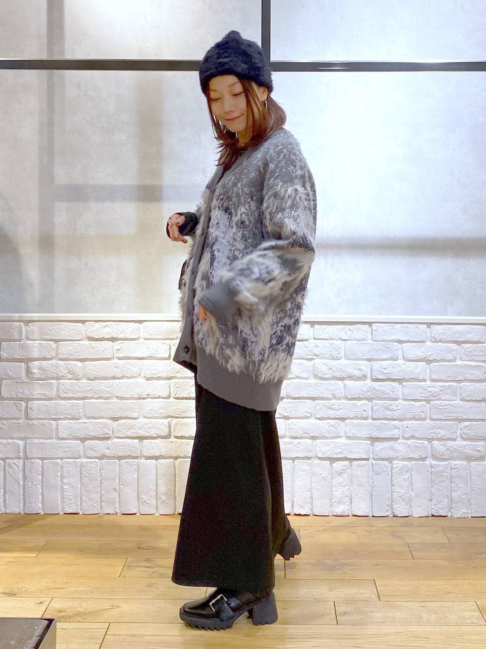 シルバー系のTシャツ/カットソー、ブラック系のブーツ、ブラック系のスカートを着用したレディースの冬コーディネートの5枚目の写真