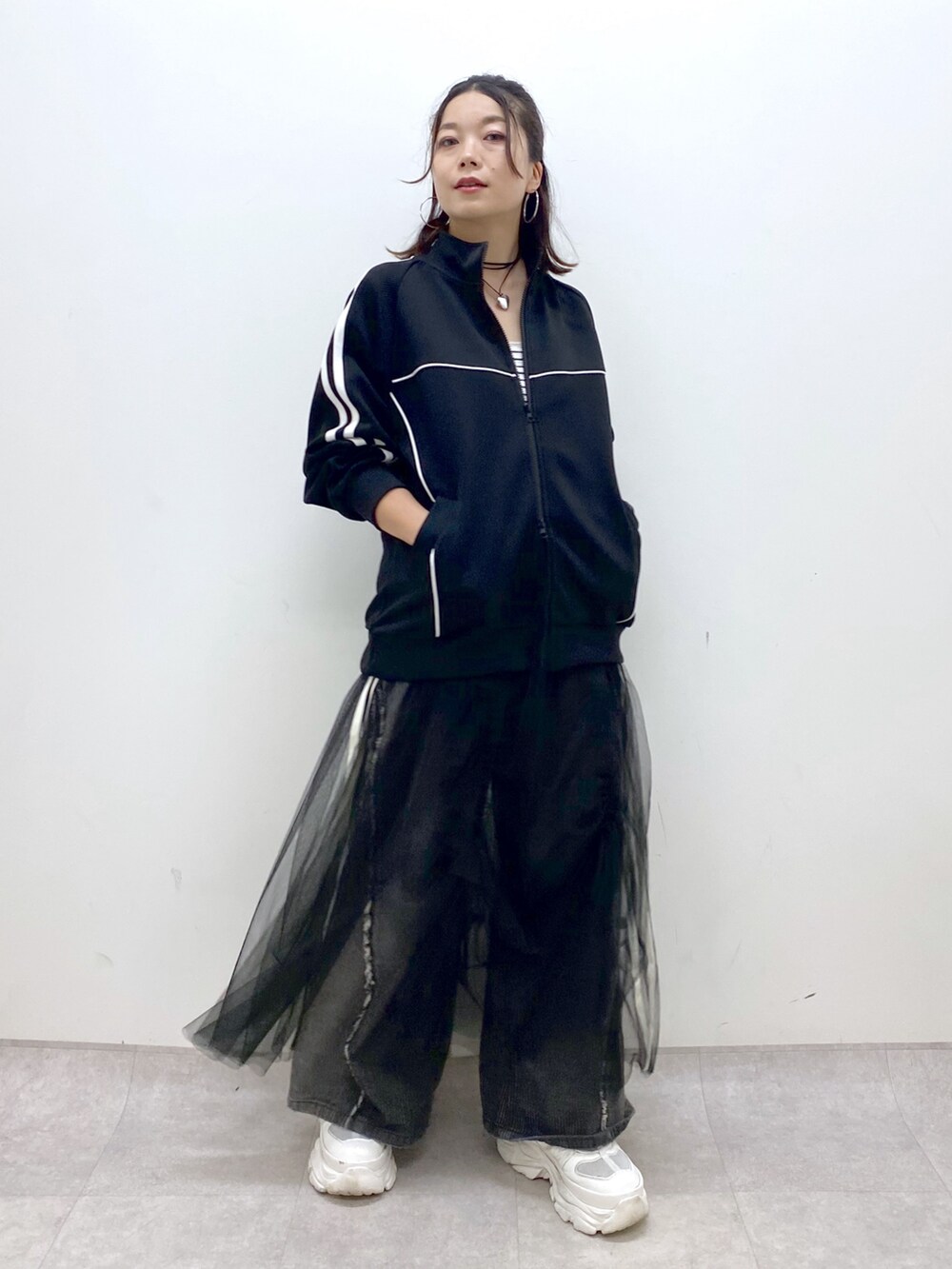 ブラック系のデニムパンツ、ホワイト系のスニーカー、ブラック系のジャージを着用したレディースの夏コーディネートの4枚目の写真