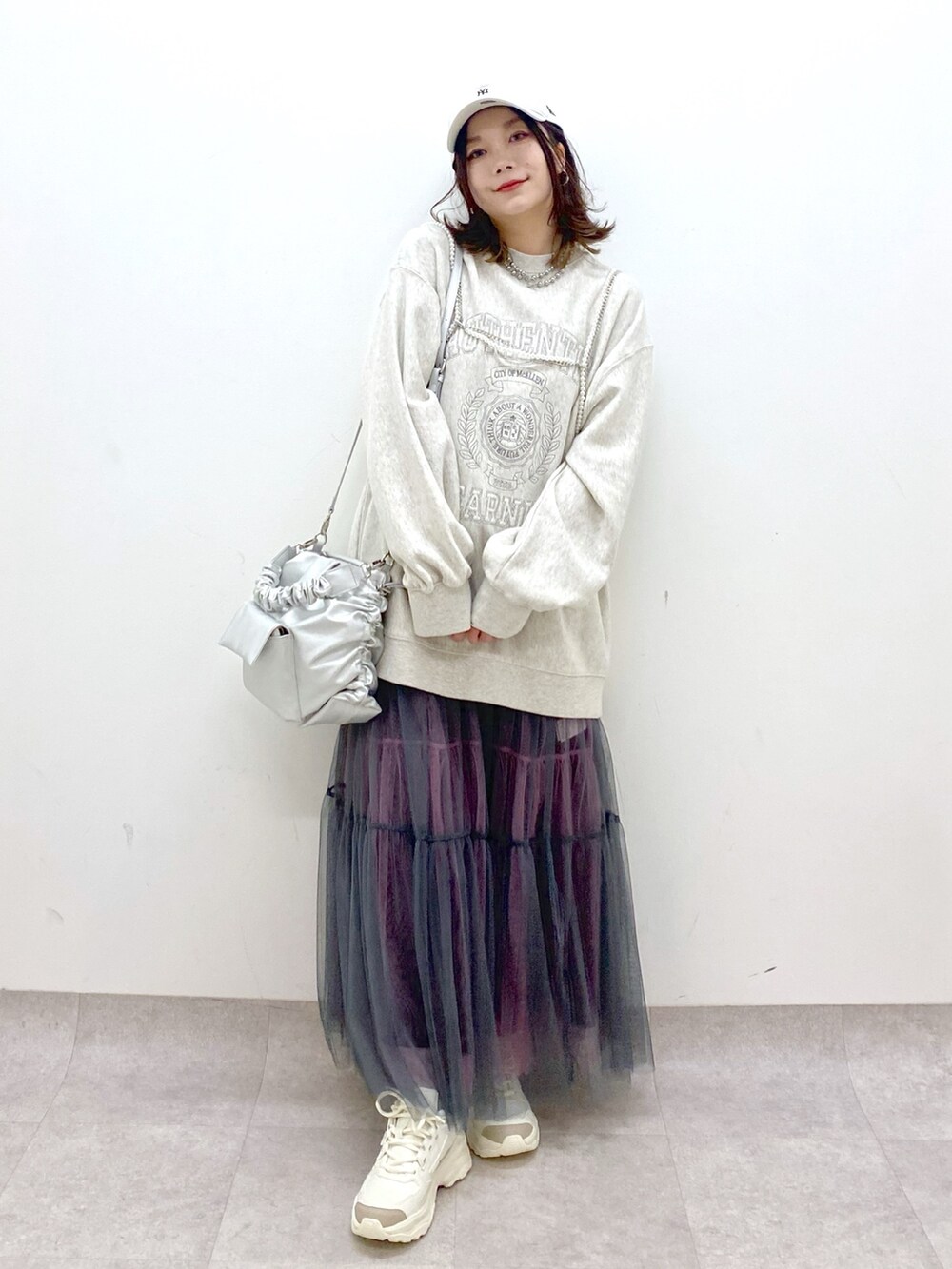 ベージュ系のスウェット、シルバー系のショルダーバッグ、グレー系のスカートを着用したレディースの春コーディネートの9枚目の写真