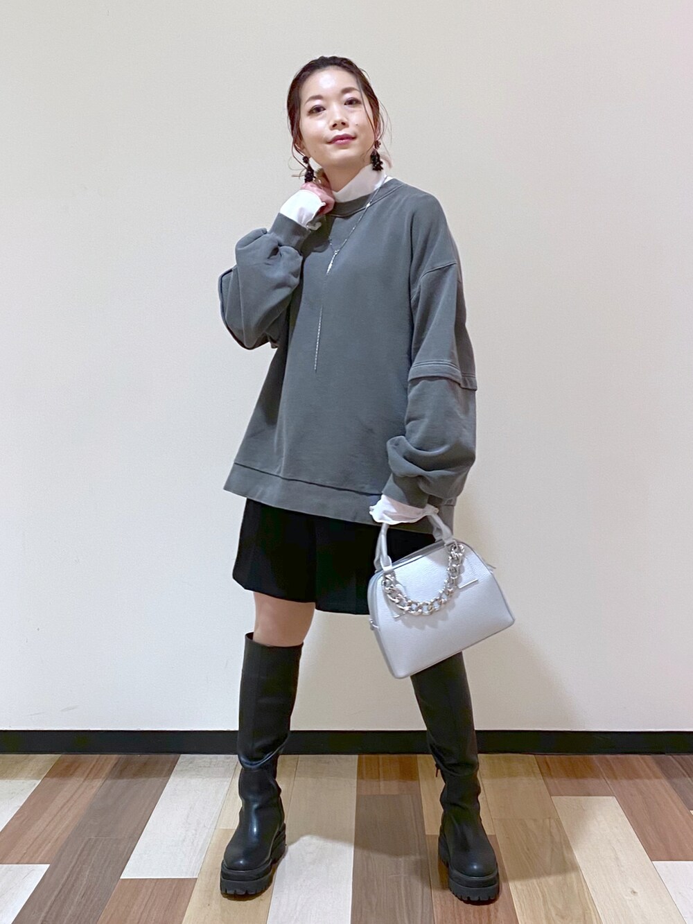 シルバー系のショルダーバッグ、ブラック系のブーツ、ブラック系のその他パンツを着用したレディースの冬コーディネートの2枚目の写真