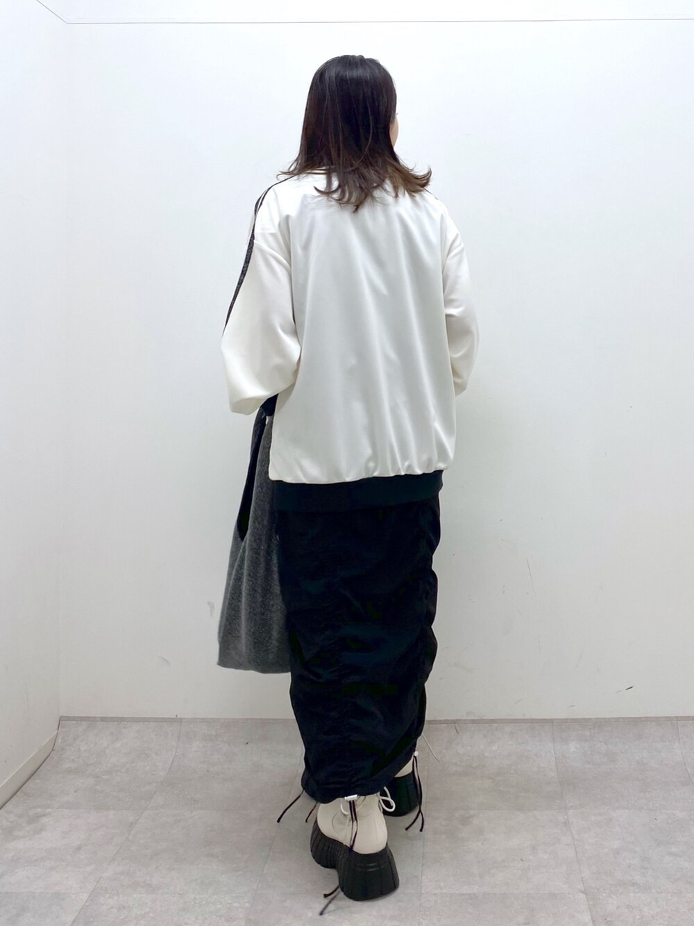 ブラック系のワンピース、ホワイト系のその他アウター、ブラック系のトートバッグを着用したレディースの冬コーディネートの4枚目の写真