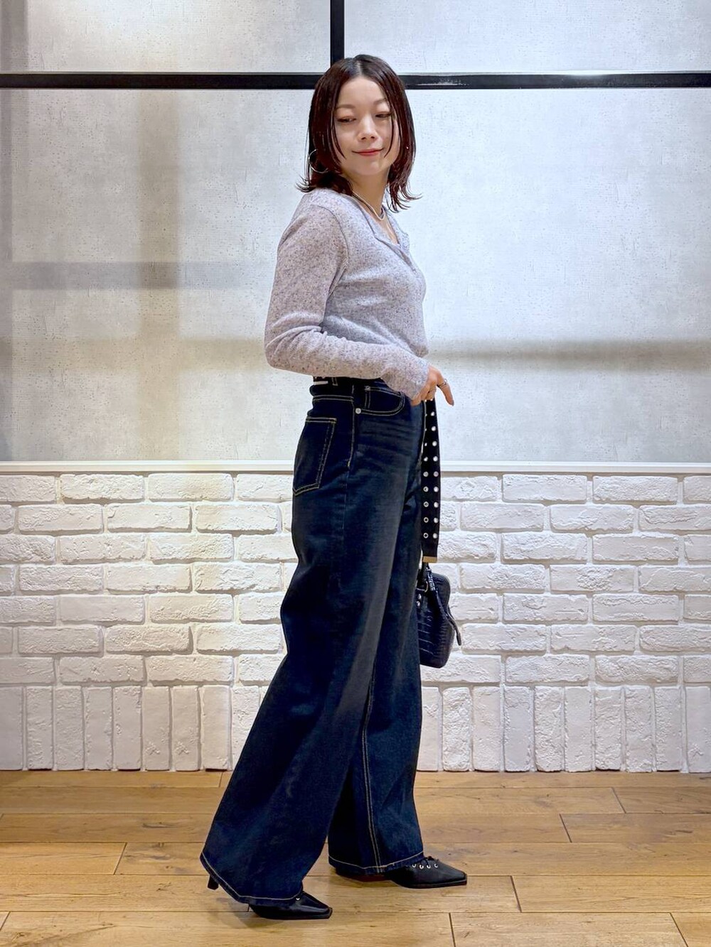 ブルー系のスラックス、ブルー系のハンドバッグ、ブルー系のタンクトップを着用したレディースの春コーディネートの5枚目の写真