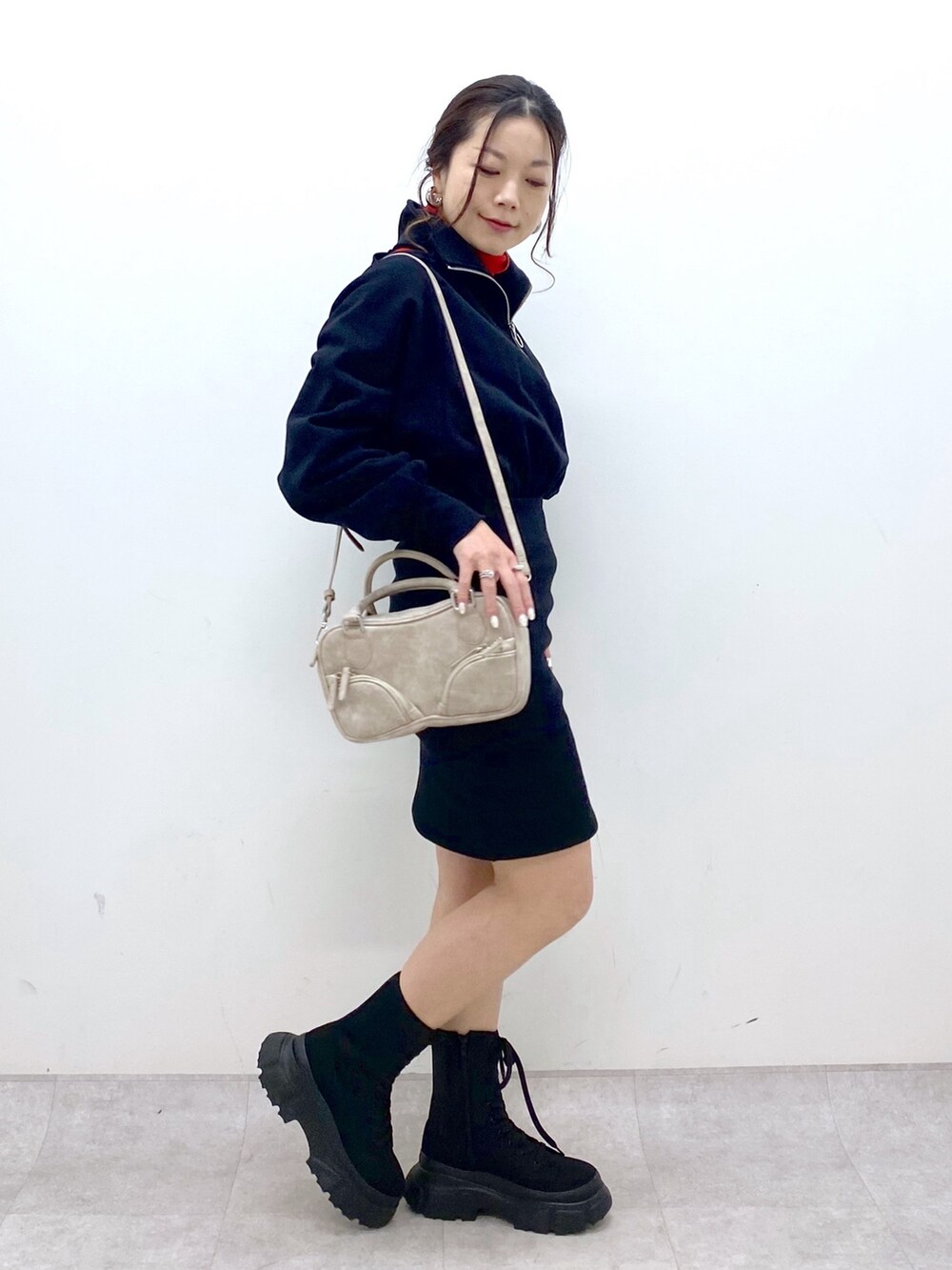 ブラック系のワンピース、レッド系のニット/セーター、ベージュ系のボストンバッグを着用したレディースの冬コーディネートの5枚目の写真