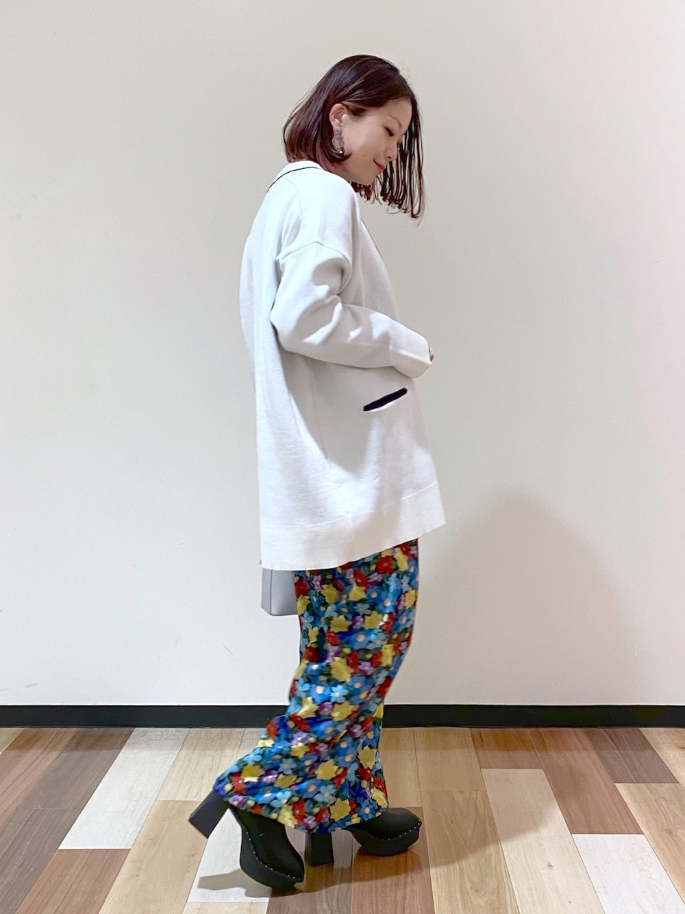 ブラック系のブーツ、シルバー系のショルダーバッグ、ホワイト系のカーディガン/ボレロを着用したレディースの冬コーディネートの3枚目の写真