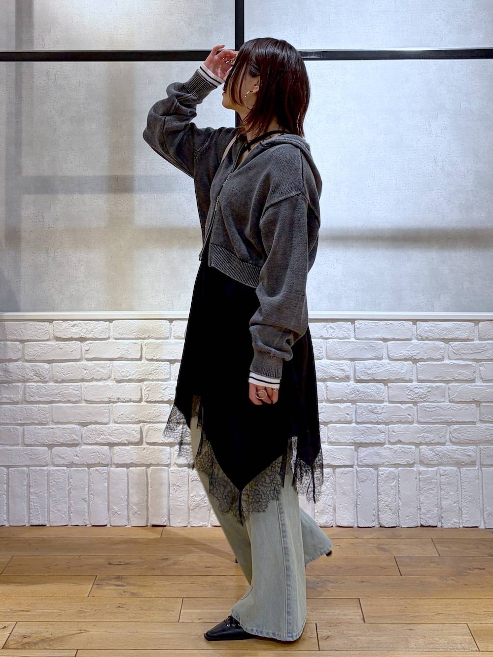 ブルー系のデニムパンツ、ホワイト系のボストンバッグ、ホワイト系のニット/セーターを着用したレディースの春コーディネートの5枚目の写真