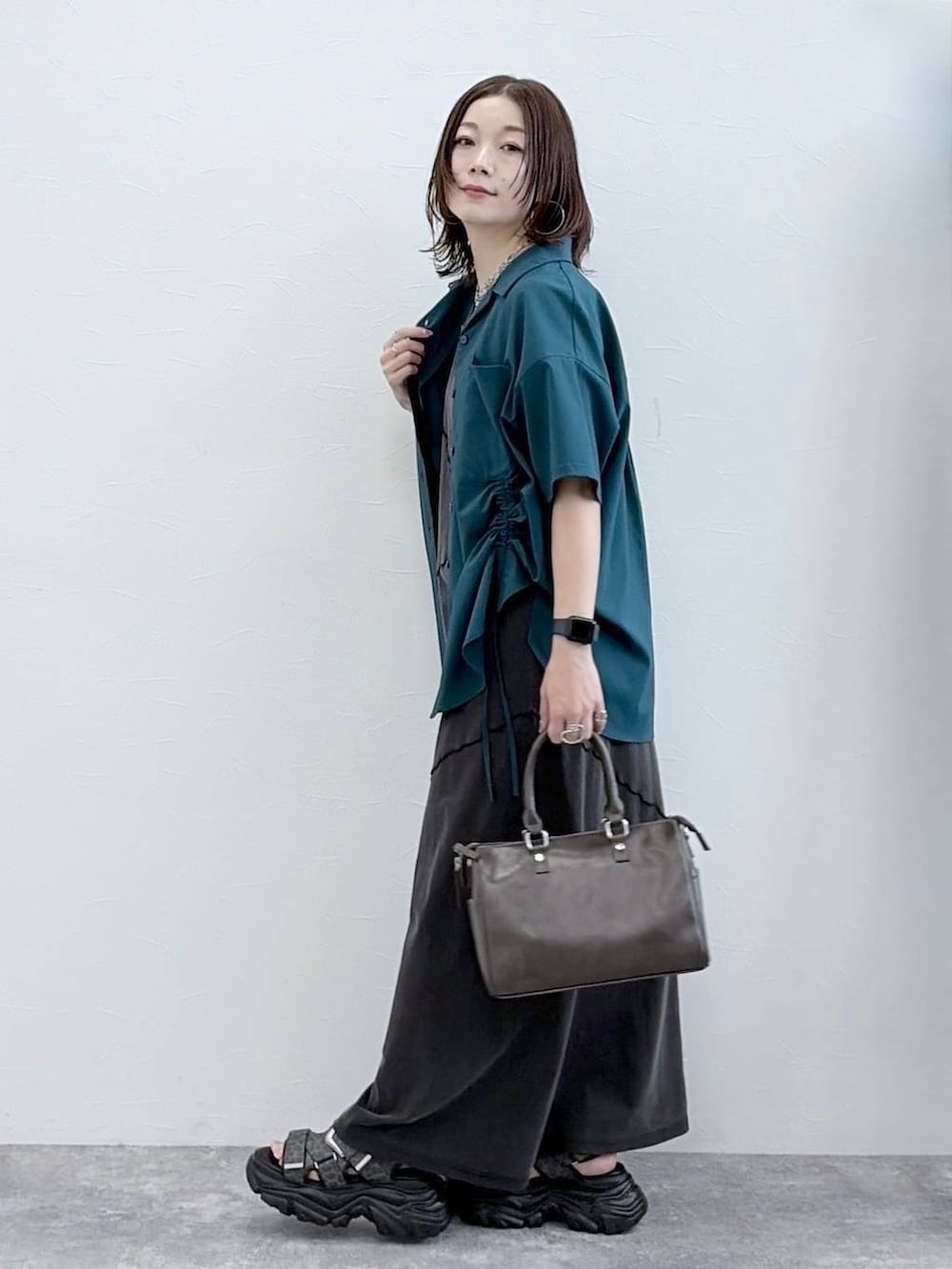 ブラック系のワンピース、グレー系のショルダーバッグ、グリーン系のシャツ/ブラウスを着用したレディースの春コーディネートの5枚目の写真