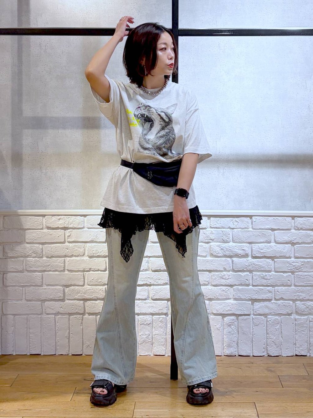 グレー系のTシャツ/カットソー、ブルー系のデニムパンツ、ブラック系のボディバッグ/ウエストポーチを着用したレディースの春コーディネートの4枚目の写真