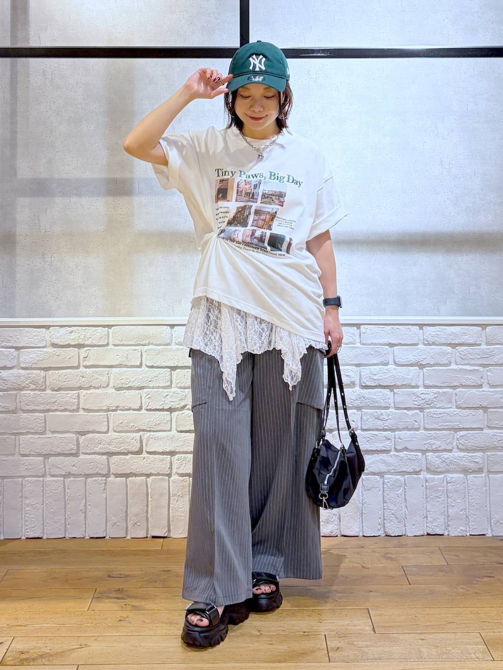 ブラック系のサンダル、ホワイト系のTシャツ/カットソー、ブラック系のトートバッグを着用したレディースの夏コーディネートの8枚目の写真