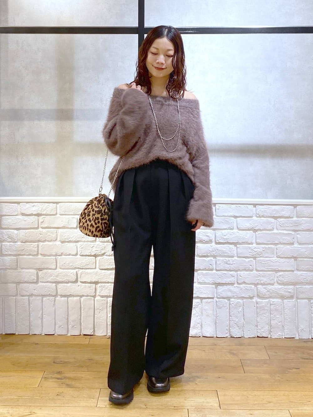 その他のブーツ、ブラック系のスラックス、ブラウン系のニット/セーターを着用したレディースの秋コーディネートの8枚目の写真