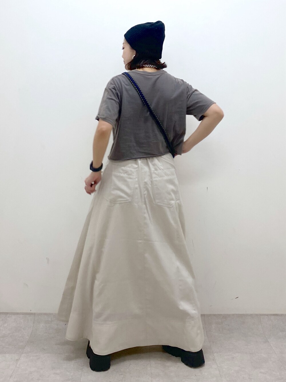 ブラック系のTシャツ/カットソー、オレンジ系のショルダーバッグ、ベージュ系のスカートを着用したレディースの夏コーディネートの7枚目の写真