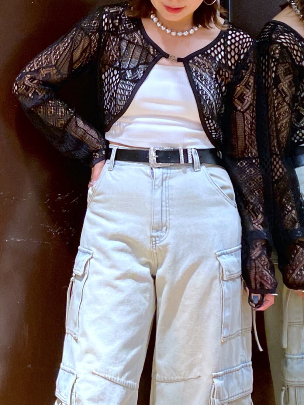 ブルー系のデニムパンツ、ホワイト系のスニーカー、ホワイト系のキャミソールを着用したレディースの夏コーディネートの2枚目の写真