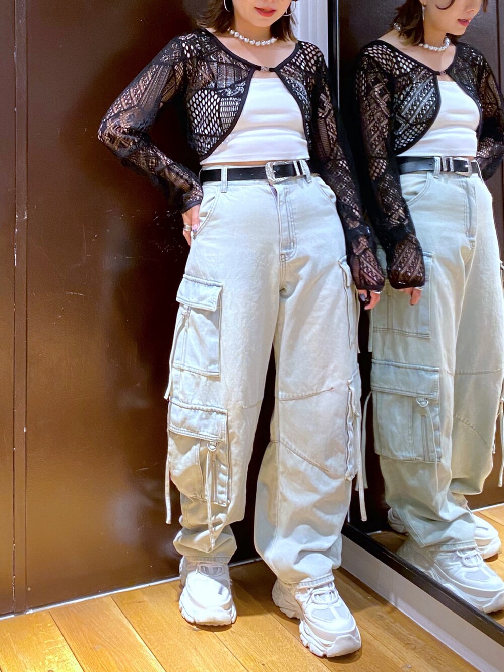 ブルー系のデニムパンツ、ホワイト系のスニーカー、ホワイト系のキャミソールを着用したレディースの夏コーディネートの3枚目の写真