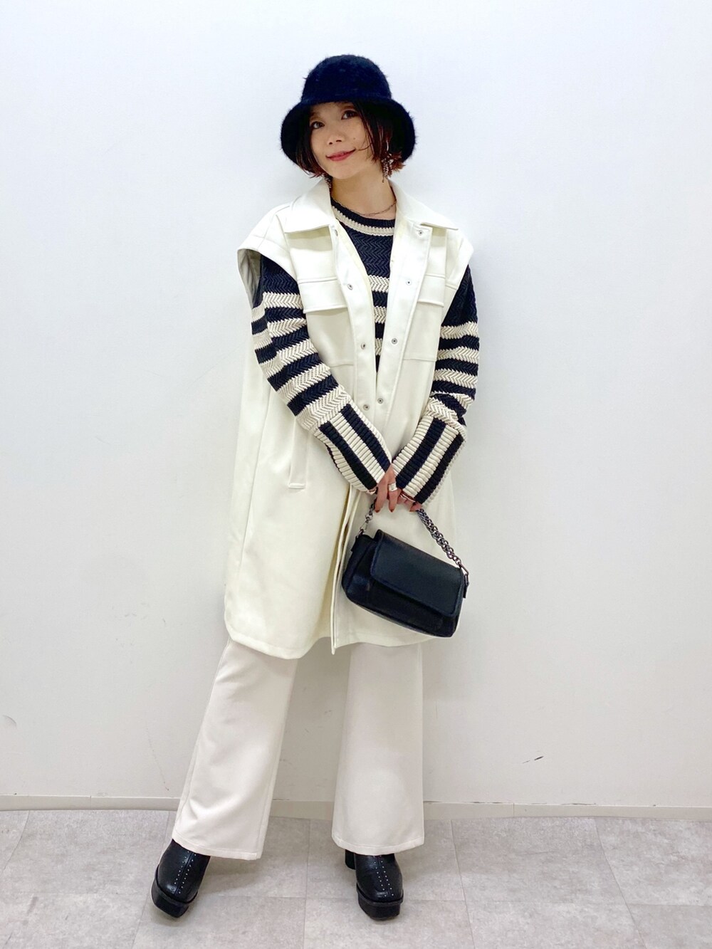 ホワイト系のジャケット/アウター、ブラック系のトップス、ホワイト系のパンツを着用したレディースの秋コーディネートの4枚目の写真