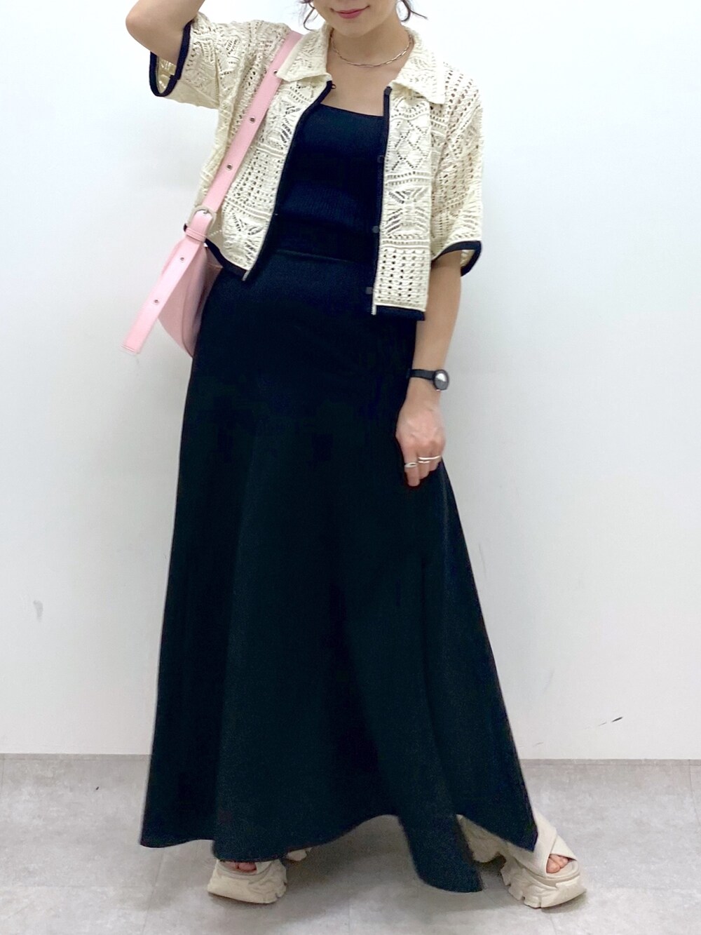 ブラック系のスカート、ホワイト系のカーディガン/ボレロ、ピンク系のショルダーバッグを着用したレディースの夏コーディネートの7枚目の写真