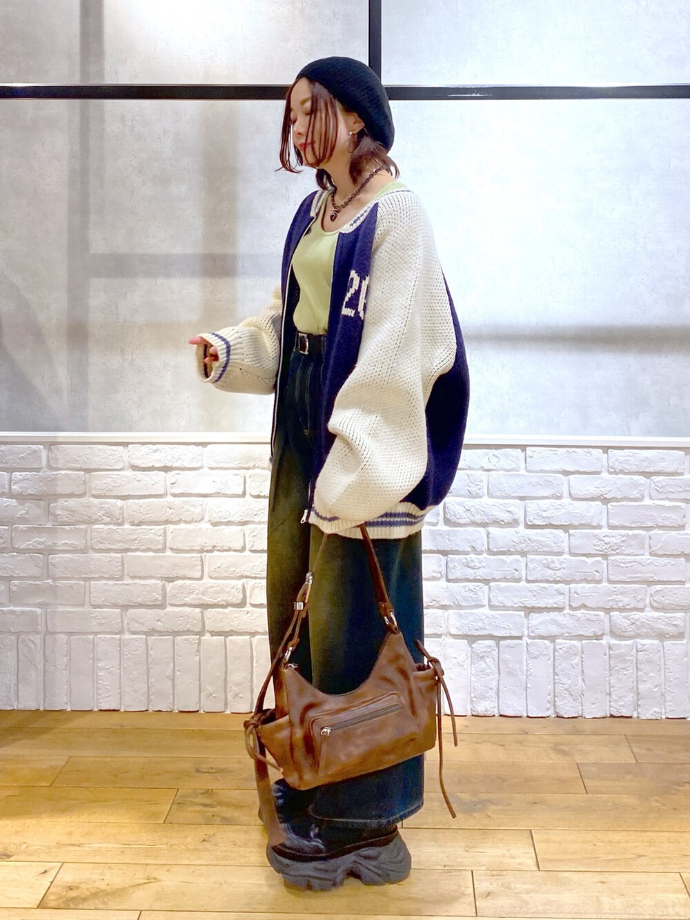 イエロー系のTシャツ/カットソー、ブラウン系のショルダーバッグ、ブルー系のデニムパンツを着用したレディースの冬コーディネートの6枚目の写真