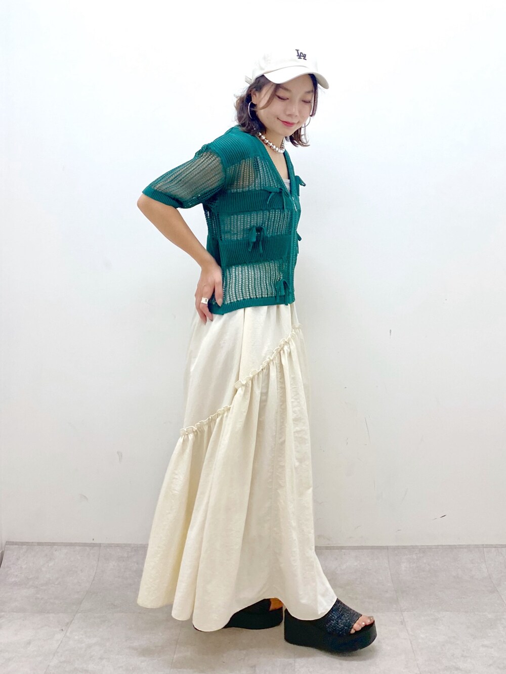 ホワイト系のスカート、グレー系のタンクトップ、シルバー系のショルダーバッグを着用したレディースの夏コーディネートの5枚目の写真