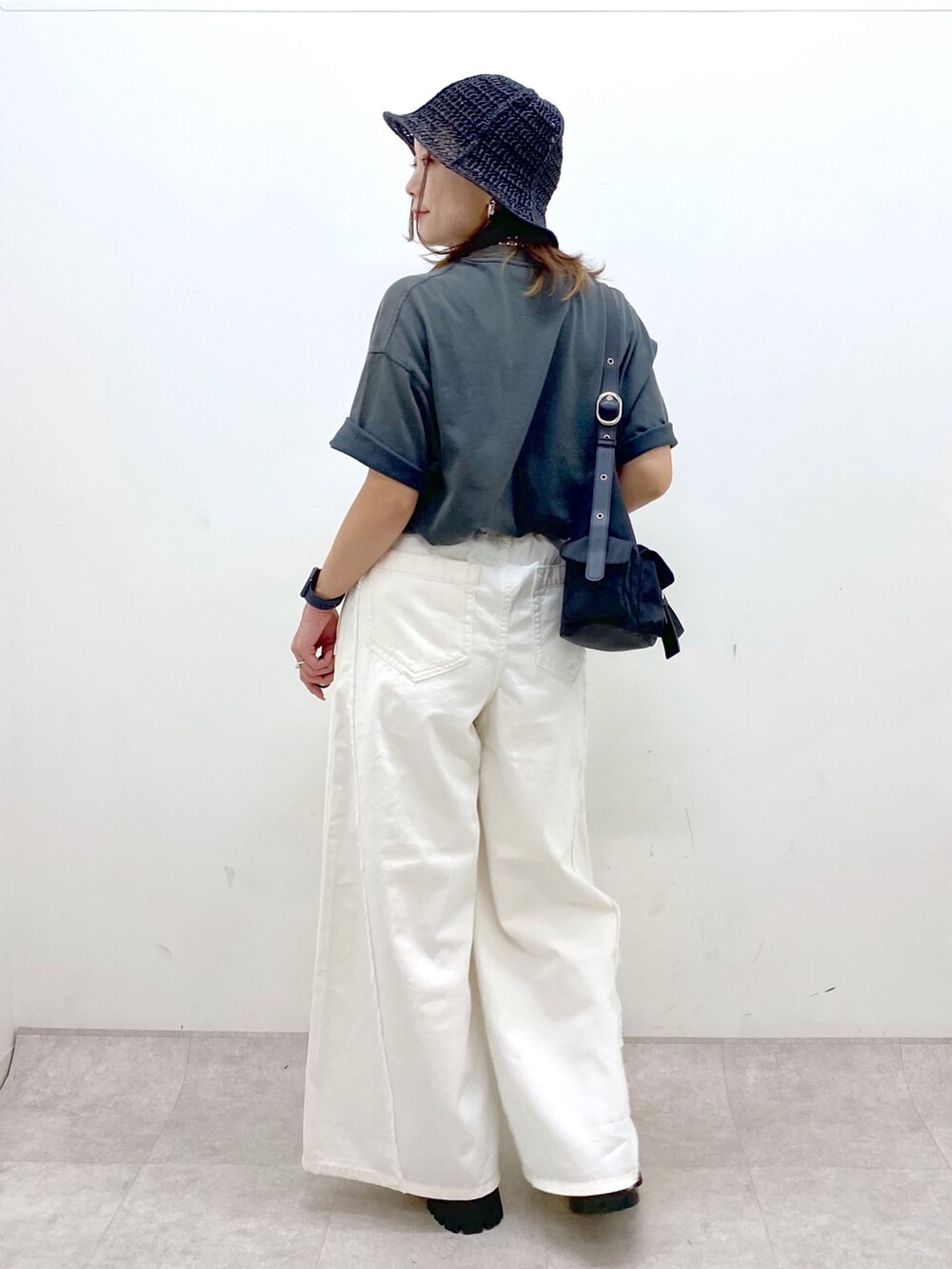 ホワイト系のデニムパンツ、ブラック系のショルダーバッグ、グレー系のTシャツ/カットソーを着用したレディースの春コーディネートの6枚目の写真