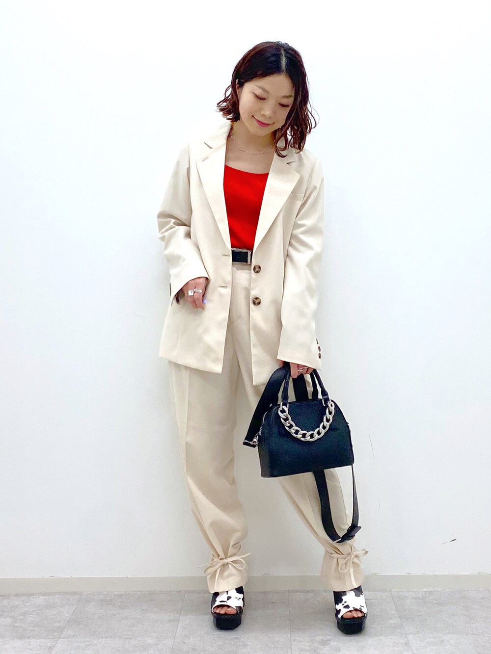 レッド系のタンクトップ、ホワイト系のその他パンツ、ブラック系のショルダーバッグを着用したレディースの春コーディネートの2枚目の写真