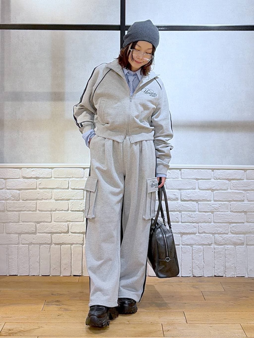 ブラック系のブーツ、ブラック系のボストンバッグ、グレー系のジャージを着用したレディースの冬コーディネートの7枚目の写真