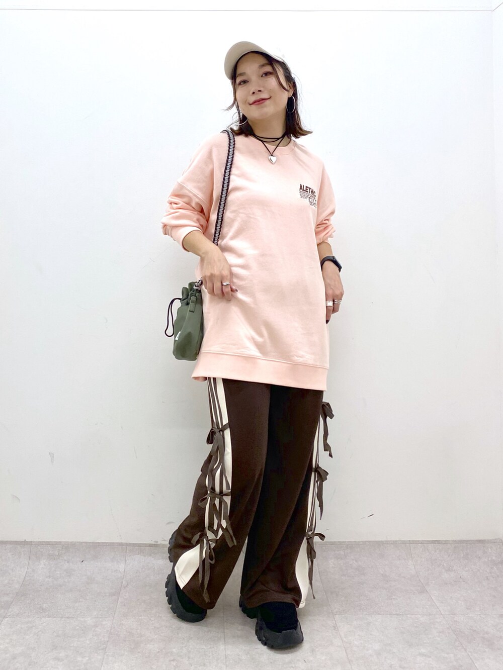ピンク系のスウェット、グリーン系のショルダーバッグ、ブラウン系のその他パンツを着用したレディースの夏コーディネートの9枚目の写真