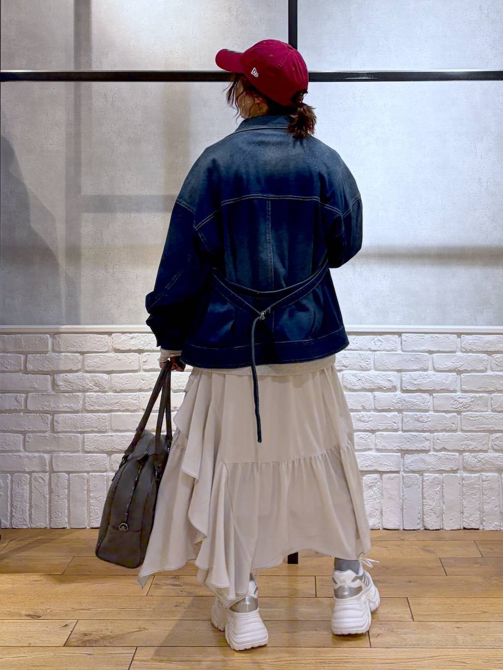 ホワイト系のスニーカー、グレー系のボストンバッグ、ベージュ系のスカートを着用したレディースの冬コーディネートの7枚目の写真